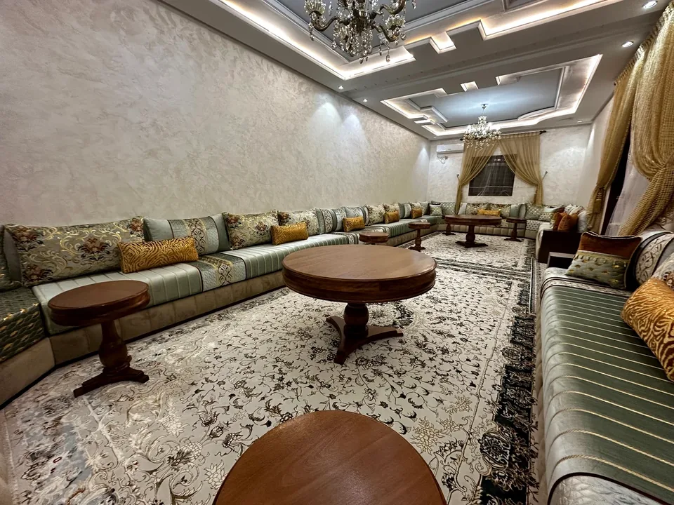 Salon marocain avec banquettes et rideaux réalisé à Guelmim par Art Déco Faissal