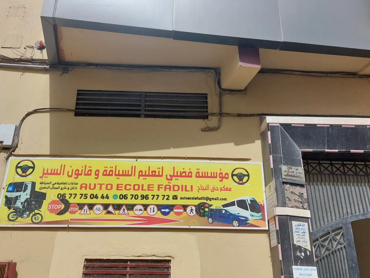 Enseigne de l’Auto École Fadili sur la façade de l’Immeuble Wanny à Dakhla, Avenue Al Masjid